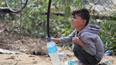 طفل يجمع الماء أثناء الحرب للشرب