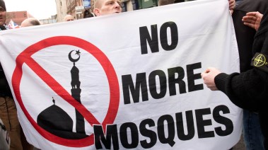 متظاهرون يرفعون لافتة كتب عليها "لا مزيد من المساجد""