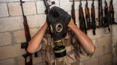 أحد مقاتلي فصائل الجيش السوري الحر ينزع قناع واقي من الغاز