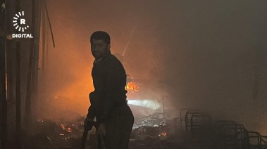 رجل إطفاء يحاول إخماد الحريق في أربيل