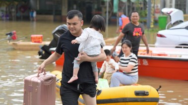 شخص يحمل إبنته وسط الفيضانات