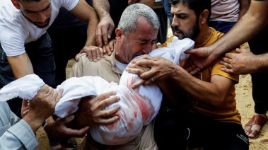رجل فلسطيني يبكي رضيعته بعد أن قتلها جيش الاحتلال