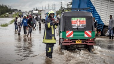 رجل إطفاء يعطي تعليمات للركاب على طريق ضربته الفيضانات في كيتينجيلا، كينيا 