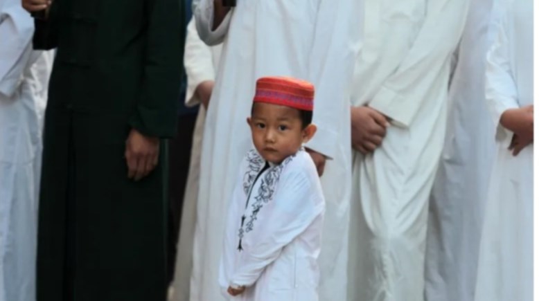 طفل صيني يحضر للصلاة في مسجد بمقاطعة شينجيانج 