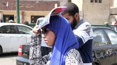 فتاة تحمي نفسها من الحرارة المرتفعة