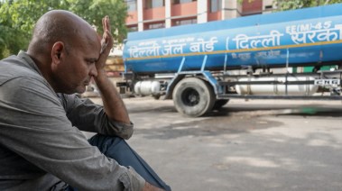 هندي يجلس مقابل حاوية ماء
