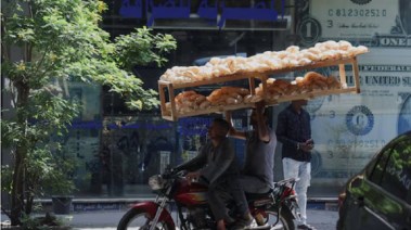 مواطن يحمل الخبز أمام شركة صرافة