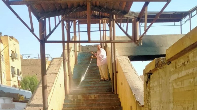 أثناء عملية تنظيف كوبري المشاة بالأقصر 