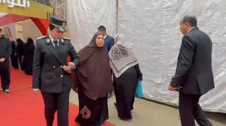 سيدة شرطة تساعد مسنة للإدلاء بصوتها الانتخابي