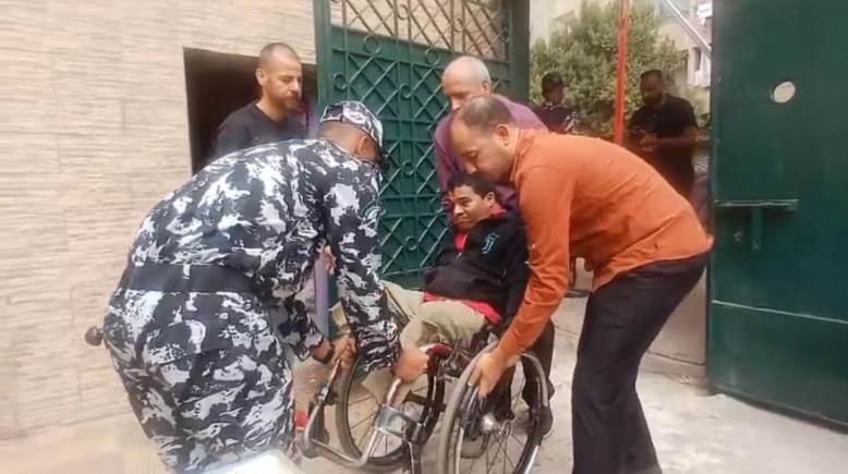 رجل شرطة يساعد شاب من ذوي الهمم