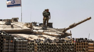 جنود من الجيش الإسرائيلي يقفون فوق برج دبابة متمركزة في جنوب إسرائيل بالقرب من الحدود مع قطاع غزة 