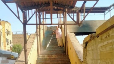 أثناء عملية تنظيف كوبري المشاة بالأقصر 