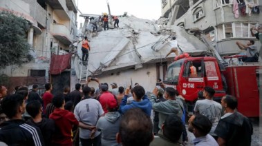 فلسطينيون يتفقدون موقع غارة إسرائيلية في مدينة غزة (رويترز)