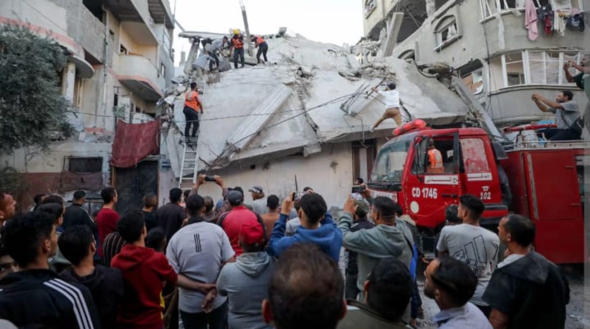 فلسطينيون يتفقدون موقع غارة إسرائيلية في مدينة غزة (رويترز)