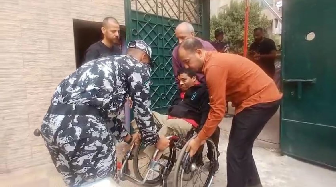 رجل شرطة يساعد شاب من ذوي الهمم