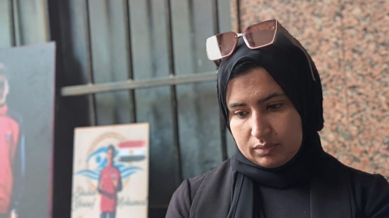 والدة الطفل يوسف بجوار صورته 