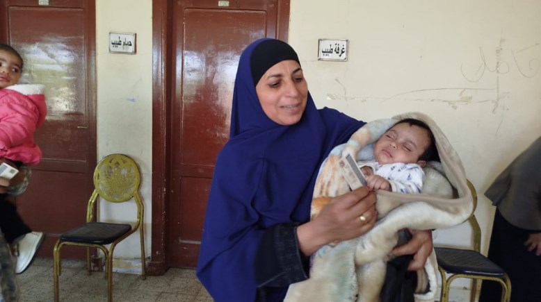 السيدة برفقة مولودها في لجنتها الانتخابية بالفيوم