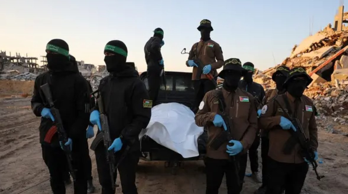 عناصر من حماس برفقة جثة عثروا عليها قبل تسليمها لإسرائيل