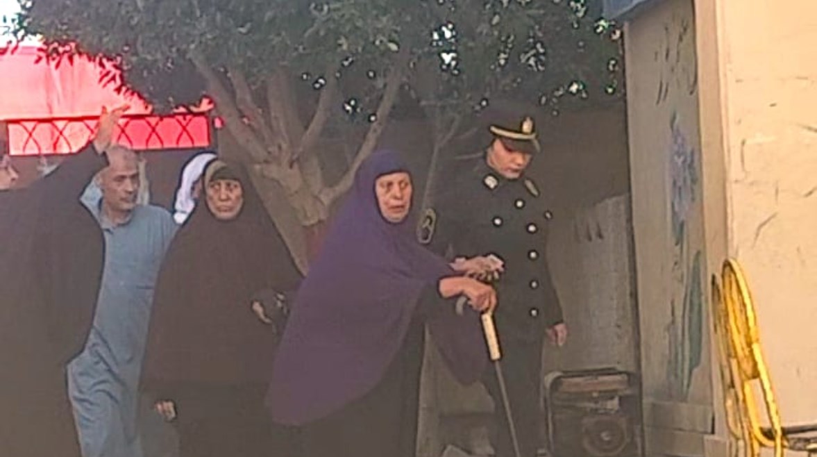 شرطية تساند سيدة مسنة