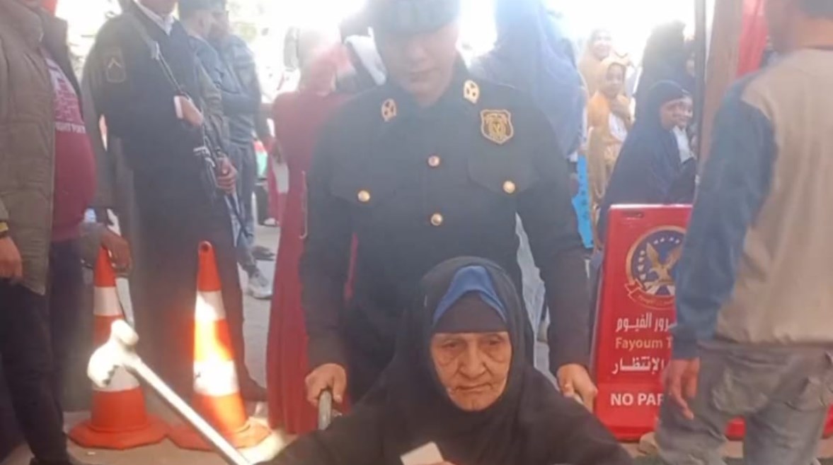 ضابطة شرطة تساعد مسنة للإدلاء بصوتها 