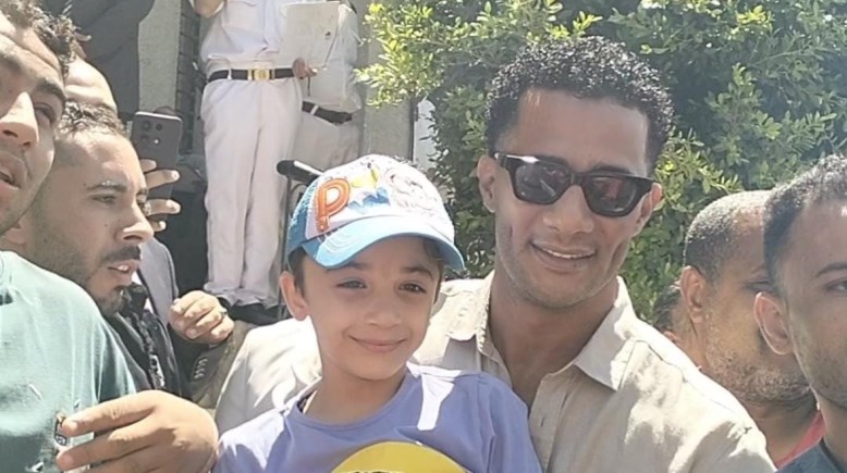 الفنان محمد رمضان في صورة تذكارية مع طفل خارج المحكمة