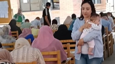 الدكتورة دينا إبراهيم تحمل رضيعة الطالبة داخل اللجنة