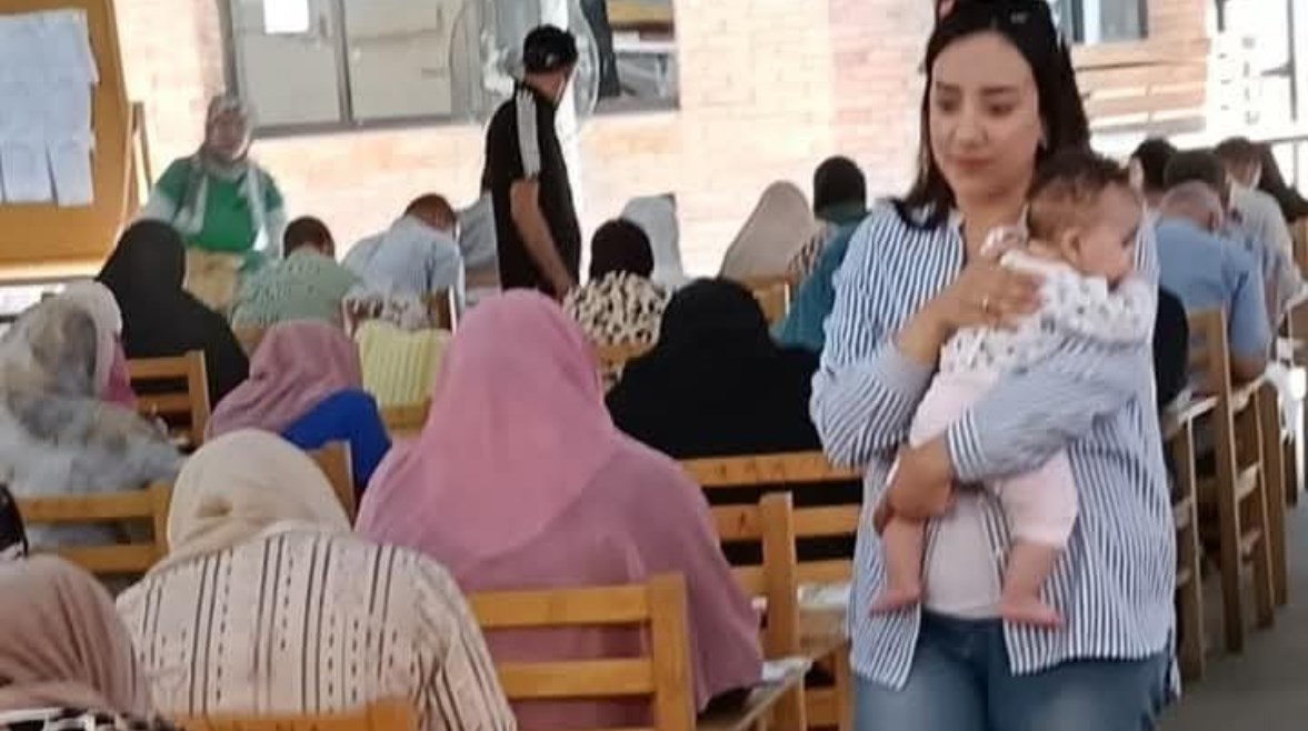 الدكتورة دينا إبراهيم تحمل رضيعة الطالبة داخل اللجنة الدكتورة دينا إبراهيم تحمل رضيعة الطالبة داخل اللجنة