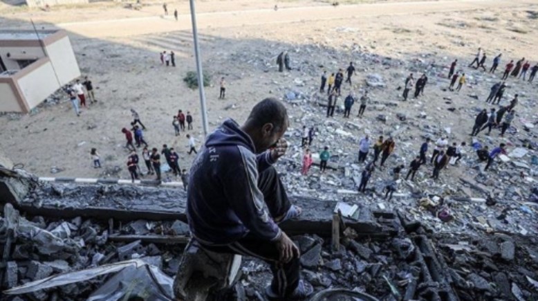فلسطيني يجلس على أنقاض منزله المدمر جراء القصف الإسرائيلي