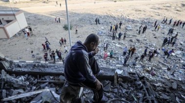 فلسطيني يجلس على أنقاض منزله المدمر جراء القصف الإسرائيلي