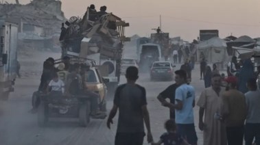 فلسطينيون ينقلون أمتعتهم على طول شاطئ مدينة غزة- 