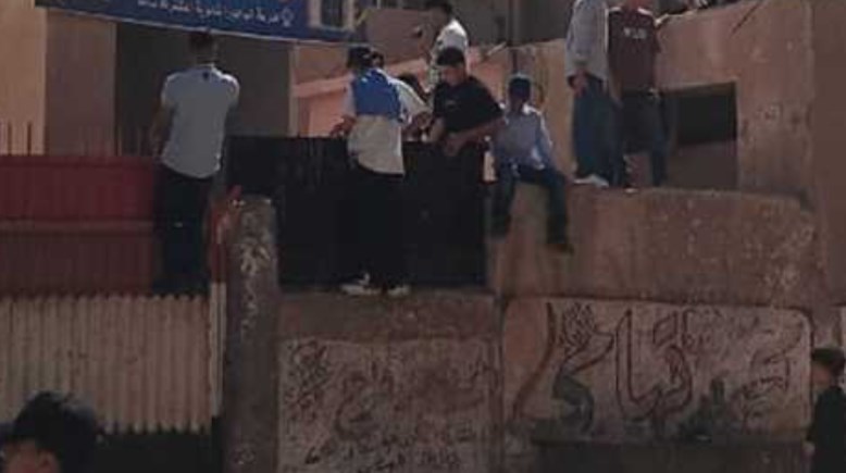 طلاب يلقون حجارة على المدرسة