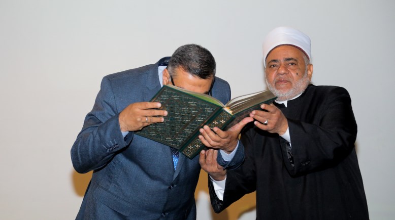 أثناء إهداء محافظ قنا المصحف