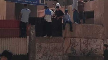 طلاب يلقون حجارة على المدرسة