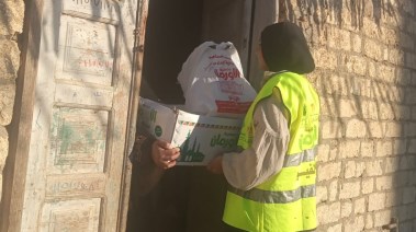لحظة توزيع الكراتين على الأسر المحتاجة