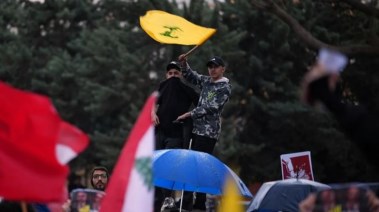 إحدى الأشخاص يلوح بعلم حزب الله في لبنان