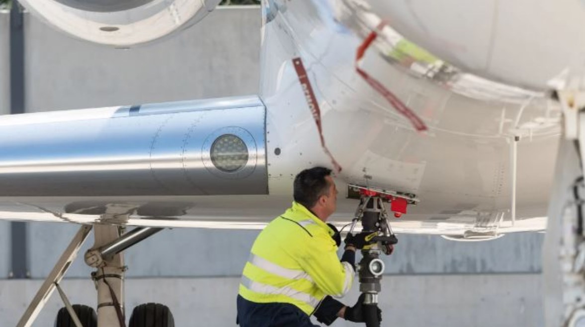 عامل يزود إحدى الطائرات بالوقود