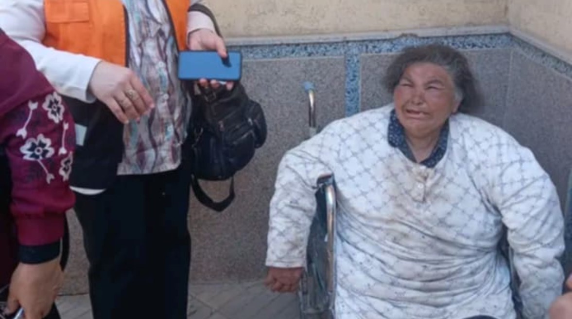 صور لسيدة مُسنة تجلس على كرسي متحرك في حالة صحية سيئة