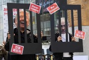 متظاهرون كوريون جنوبيون يجسدون صورة لترامب ونتنياهو خلف القضبان 