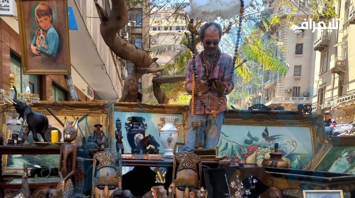 أحد باعة التحف يفحص قطعة من الأنتيك 