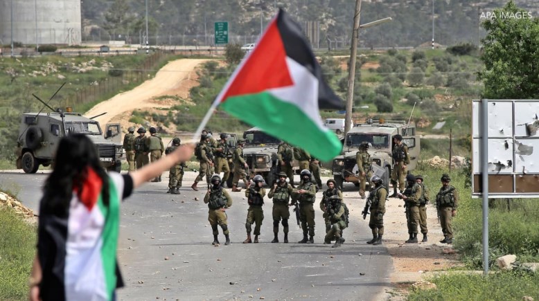 فناة ترفع العلم الفلسطيني في وجه جنود الإحتلال