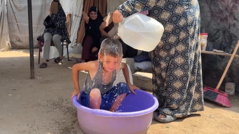 أم تسكب المياه على ابنها بسبب الحر في غزة