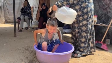 أم تسكب المياه على ابنها بسبب الحر في غزة