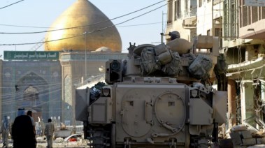 مركبة برادلي مدرعة تابعة للجيش الأمريكي، من فرقة الفرسان الأولى، تحرس شارعًا يؤدي من المقبرة إلى مرقد الإمام علي، في النجف